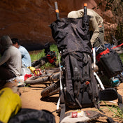 Back view of Hyperlite Mountain Gear's Porter 70 Pack in Black unrolled with hikers surrounding