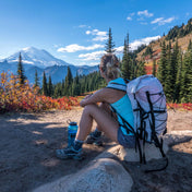 Hiker in mountains wearing Hyperlite Mountain Gear's Summit 30 Pack in White