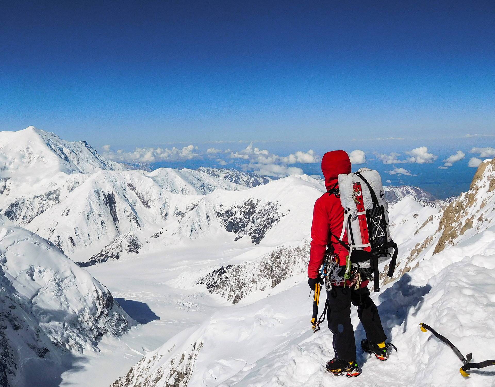 A man is standing on top of a snowy mountain.