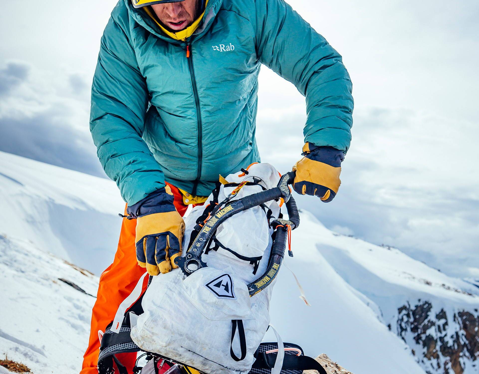 A man with a backpack on top of a snowy mountain.